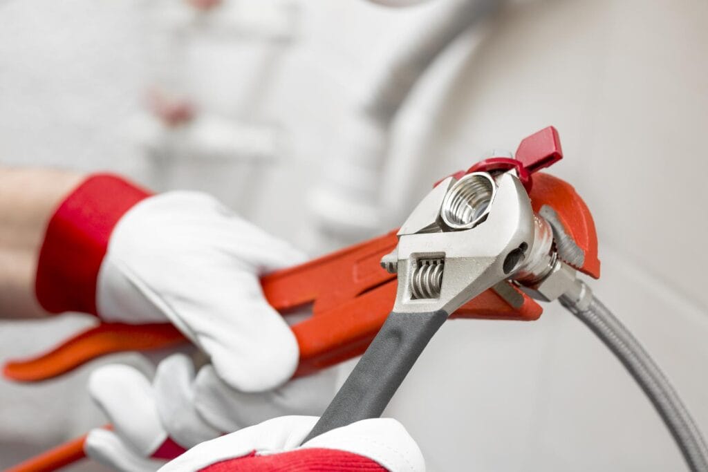Plumber holding pipe wrenches for an emergency repair in Boca Raton