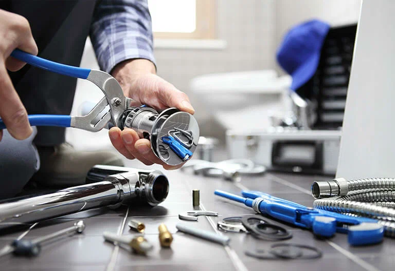 Technician repairing a plumbing fixture with professional tools in Boca Raton