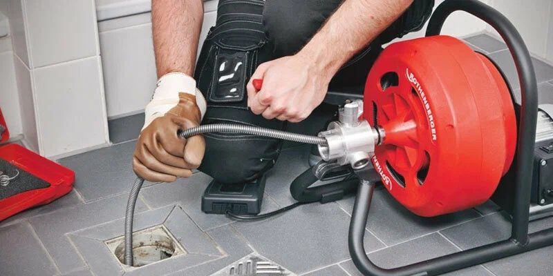 Plumber using a drain-cleaning machine in Boca Raton
