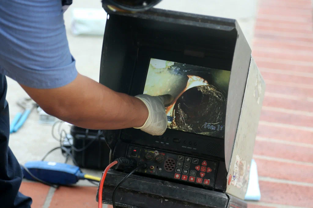 Technician viewing a drain inspection camera in Boca Raton