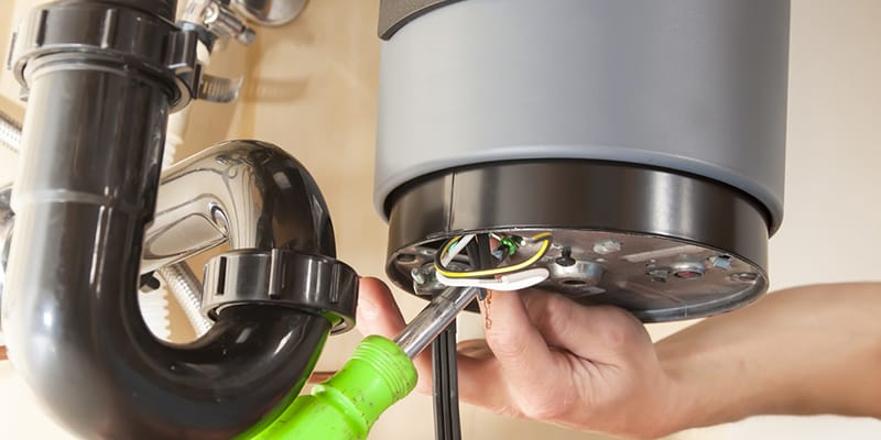 Technician repairing the heating element of a water heater in Boca Raton
