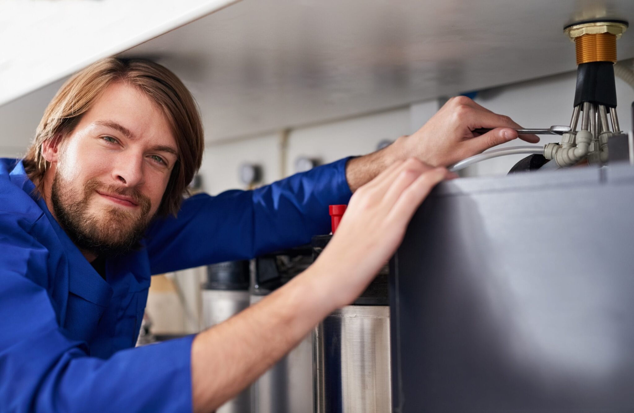 Technician servicing a residential water heater tank in Boca Raton